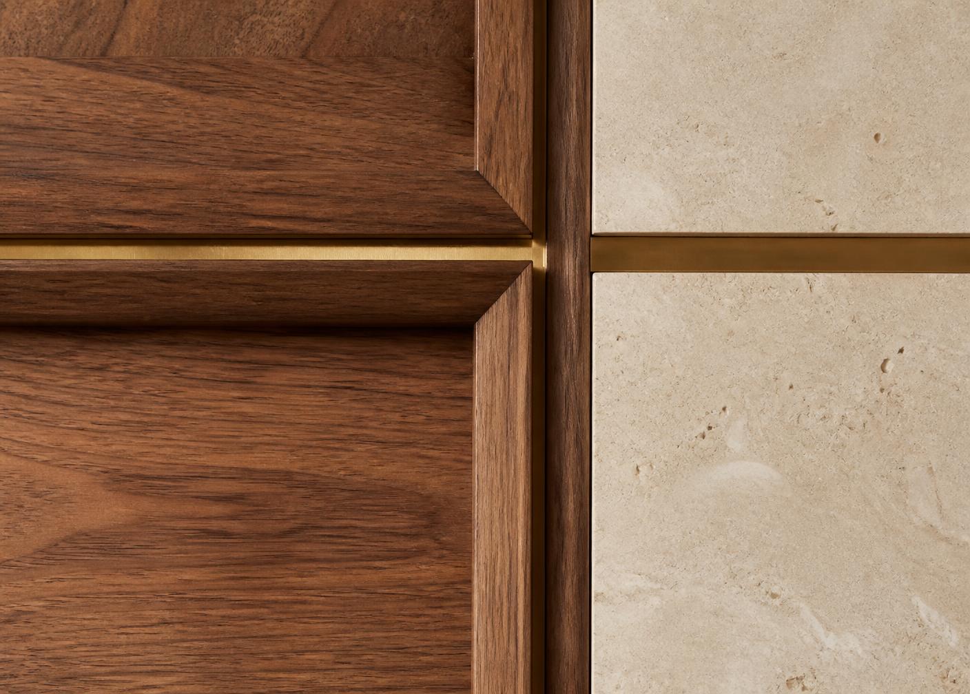 Close-up of walnut joinery meeting limestone with a fine brass reveal